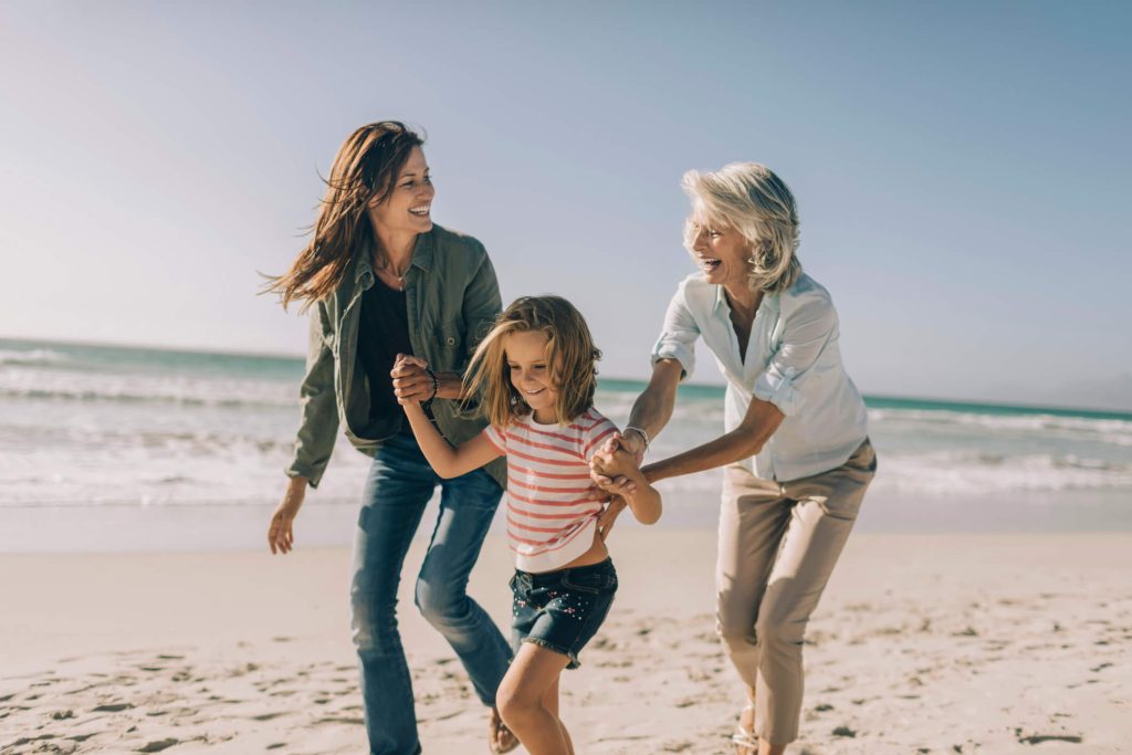 Grandmother, mother, and daughter on a sunny day at the beach